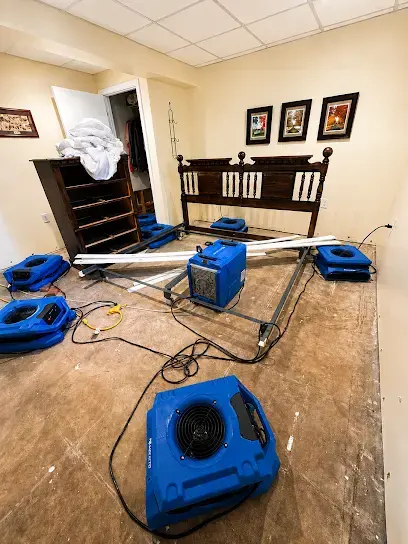 Air movers drying a bedroom floor after a water loss in Overland Park