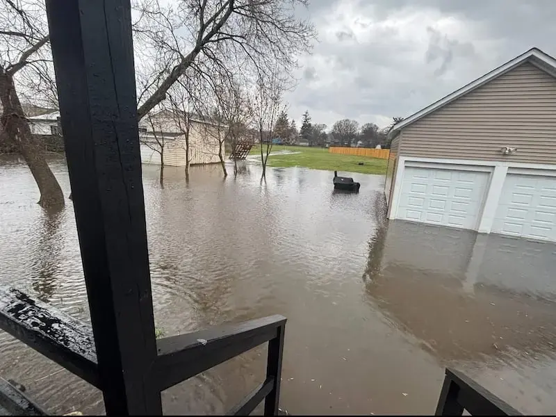 Storm water flooding a suburban yard and garage after heavy rain in Johnson County